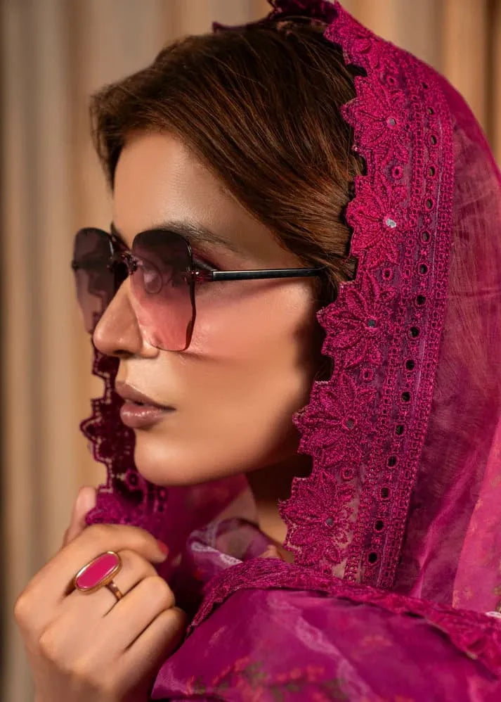 Woman wearing a pink lace headscarf and sunglasses with a blurred background