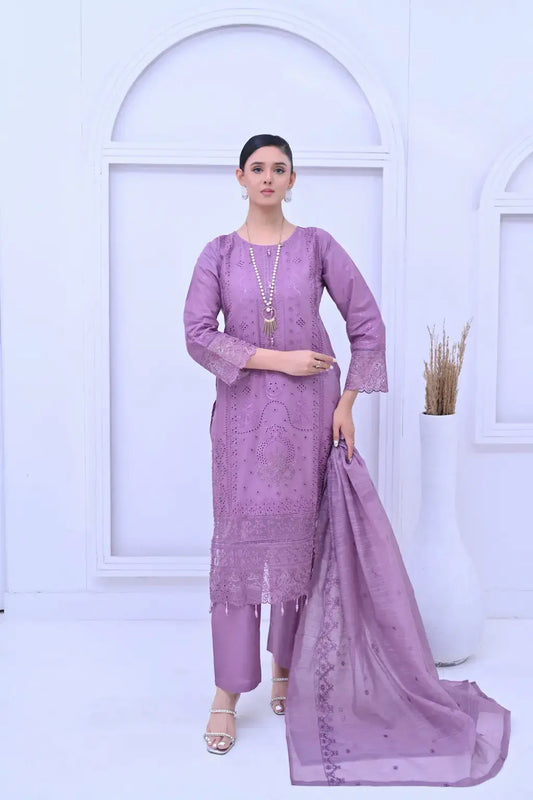 Woman modeling a lavender 3-piece embroidered suit with cutwork details and a sheer dupatta.