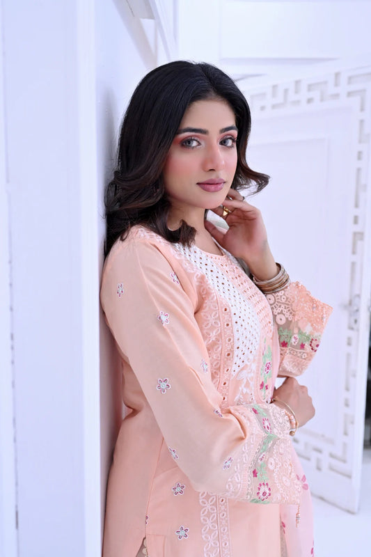 Woman wearing a peach floral traditional outfit against a white background