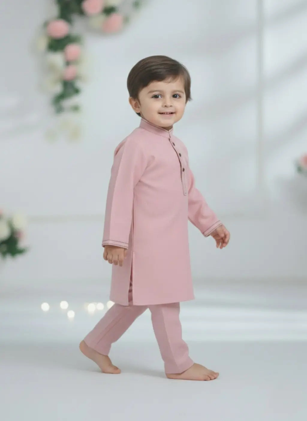 Child wearing a pink traditional outfit on a white background