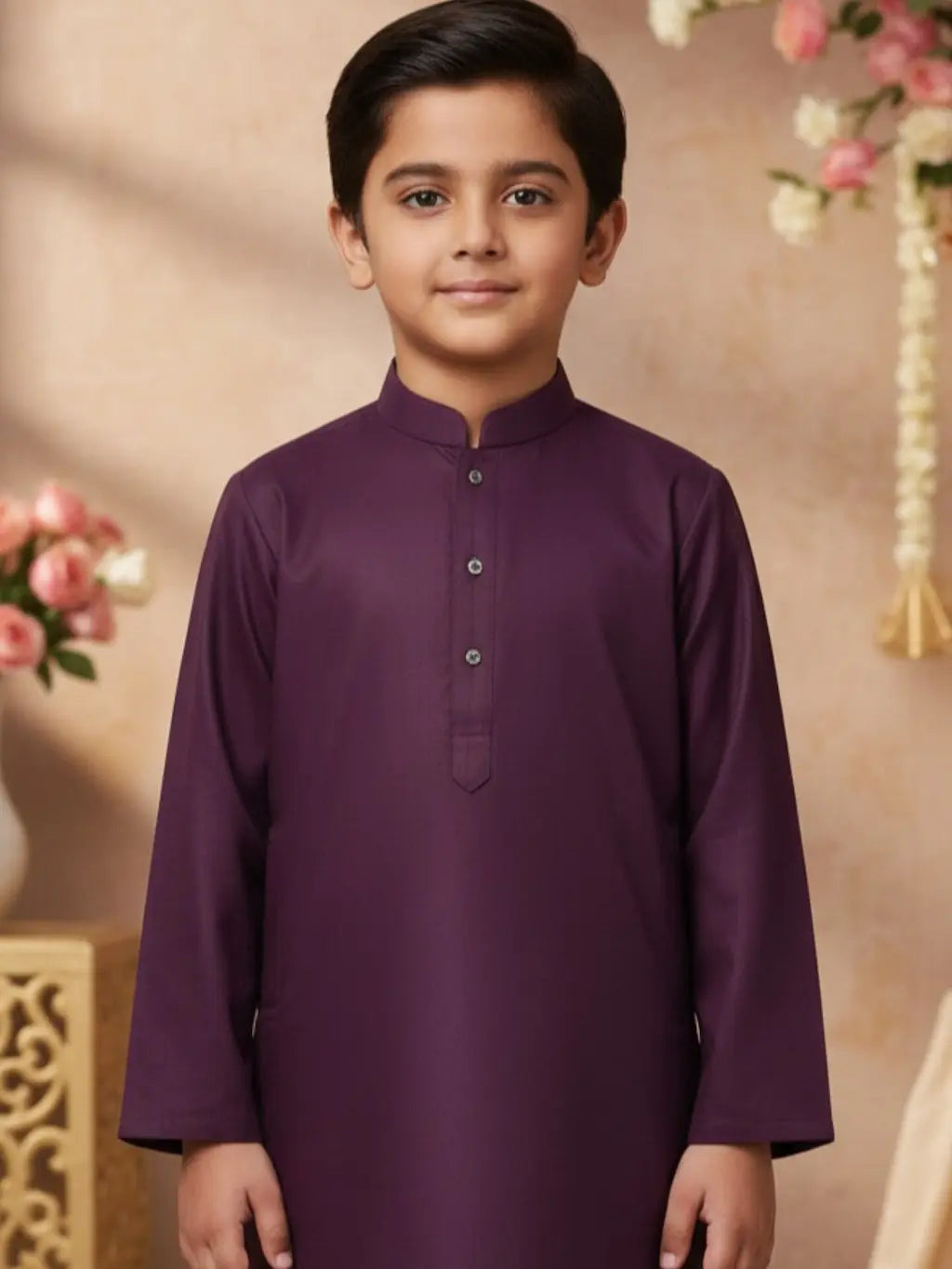 Young boy wearing a purple kurta with a decorative background