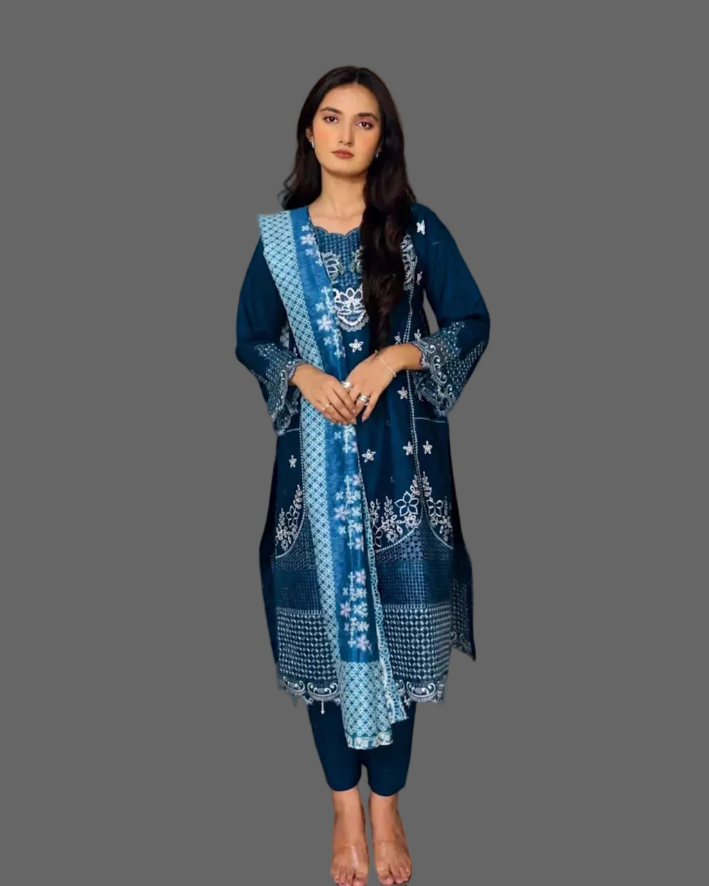 Woman wearing a blue embroidered outfit in a warm-toned indoor setting