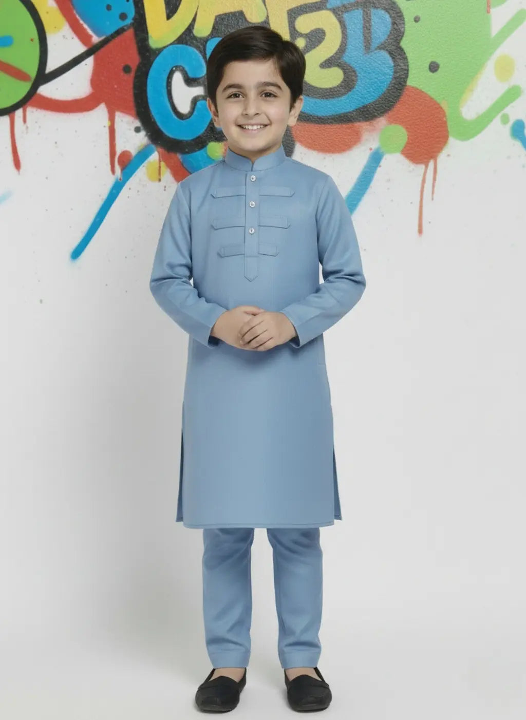 Child wearing a light blue kurta with a colorful graffiti wall in the background