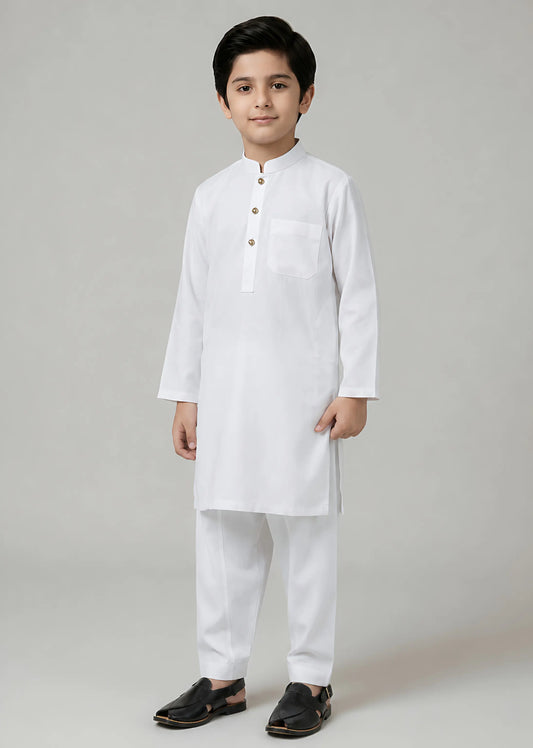 Young boy wearing a white kurta with pants on a gray background