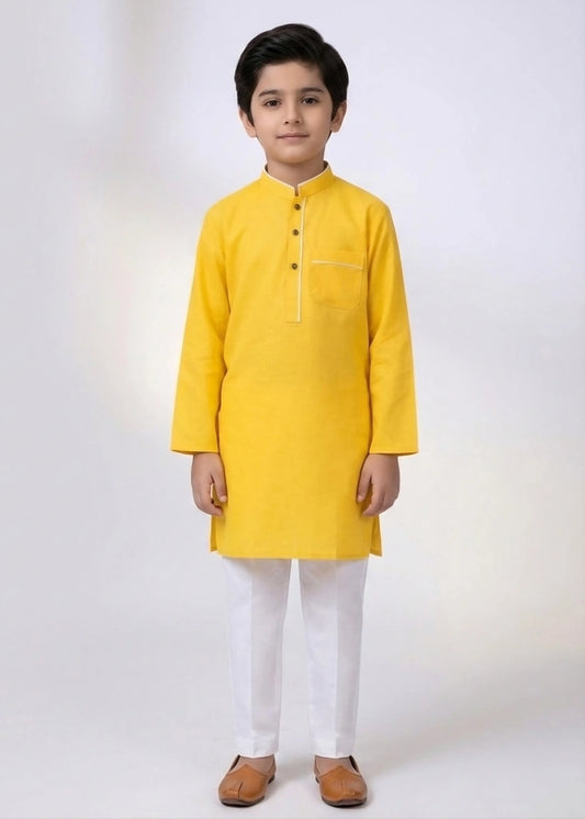 Child wearing a yellow kurta with white pants on a white background