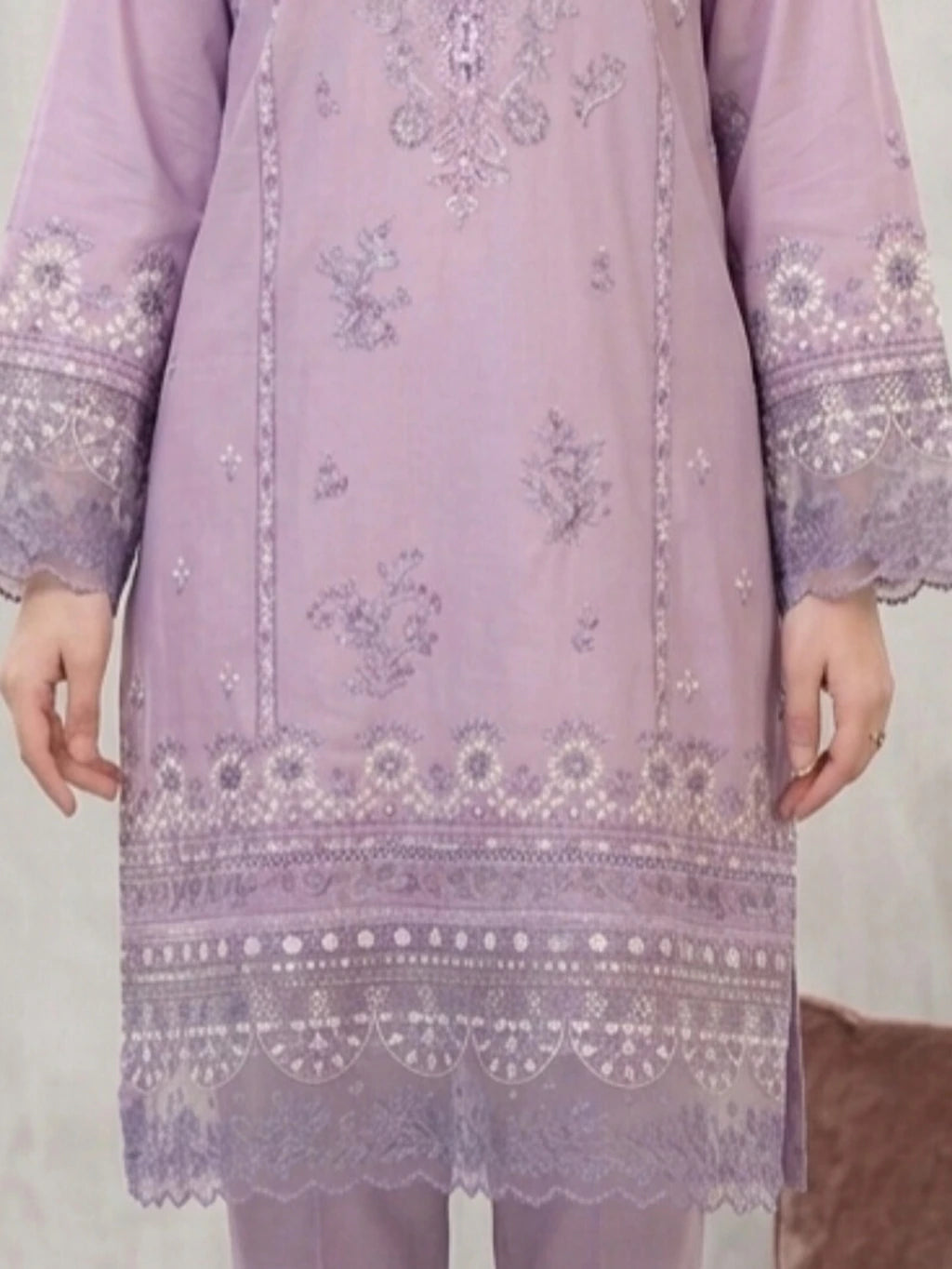 Lavender embroidered dress with intricate patterns on a plain background