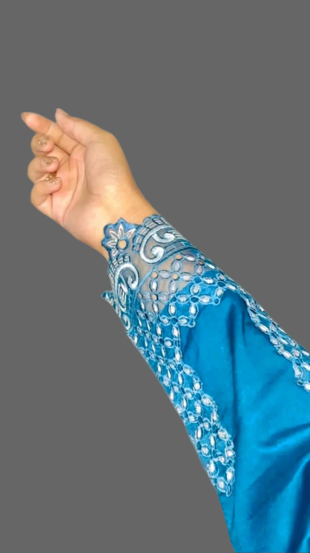 Teal Blue sleeve with intricate lace detailing on a marble background