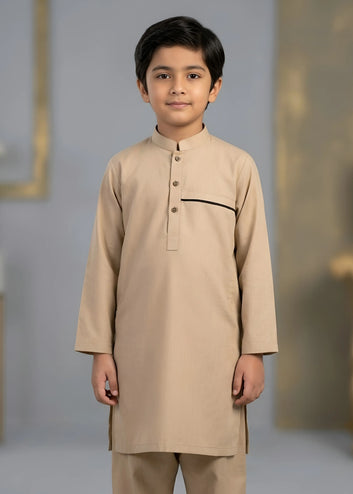 Young boy wearing a beige traditional outfit against a neutral background