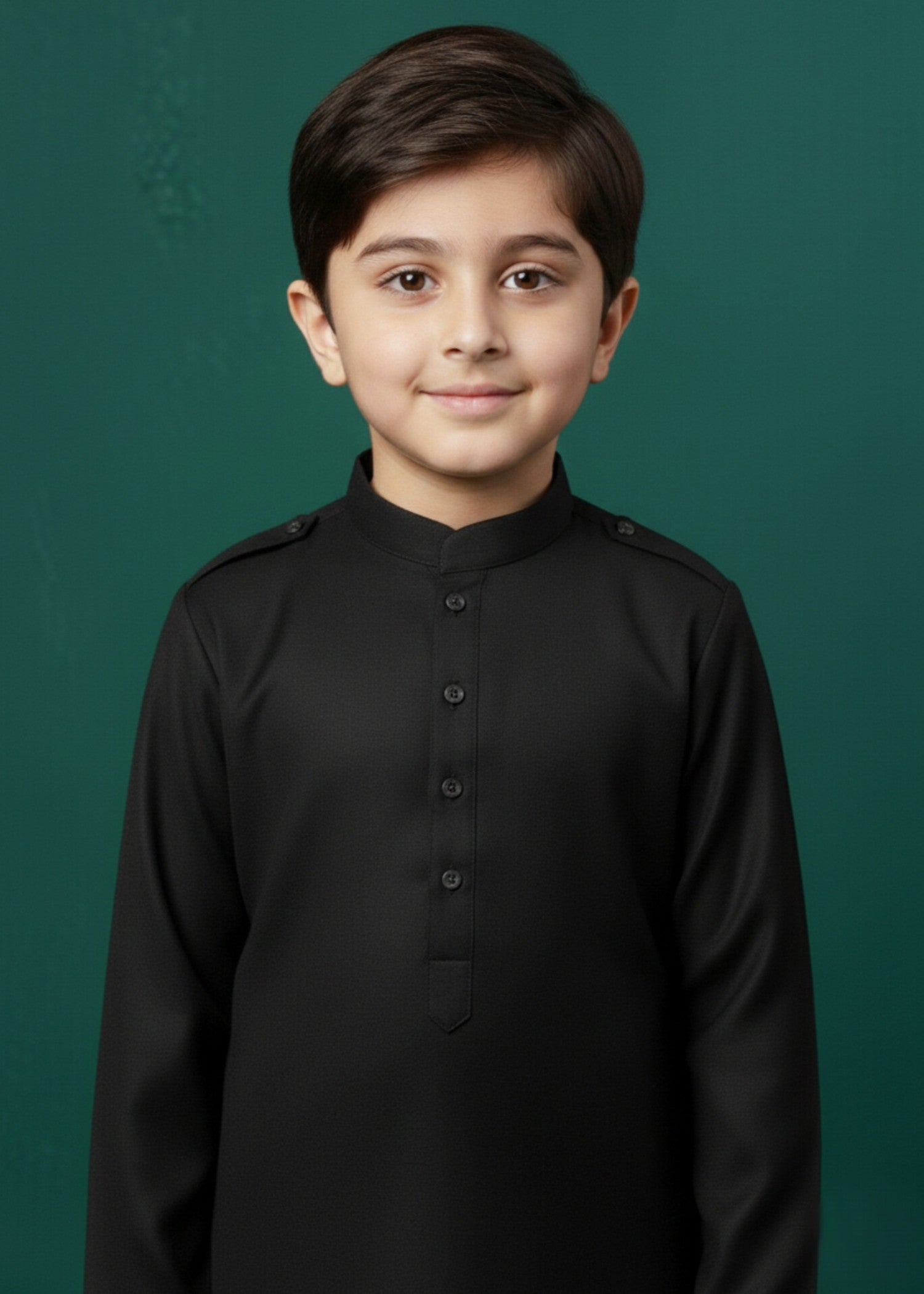 Young boy wearing a black traditional outfit against a green background