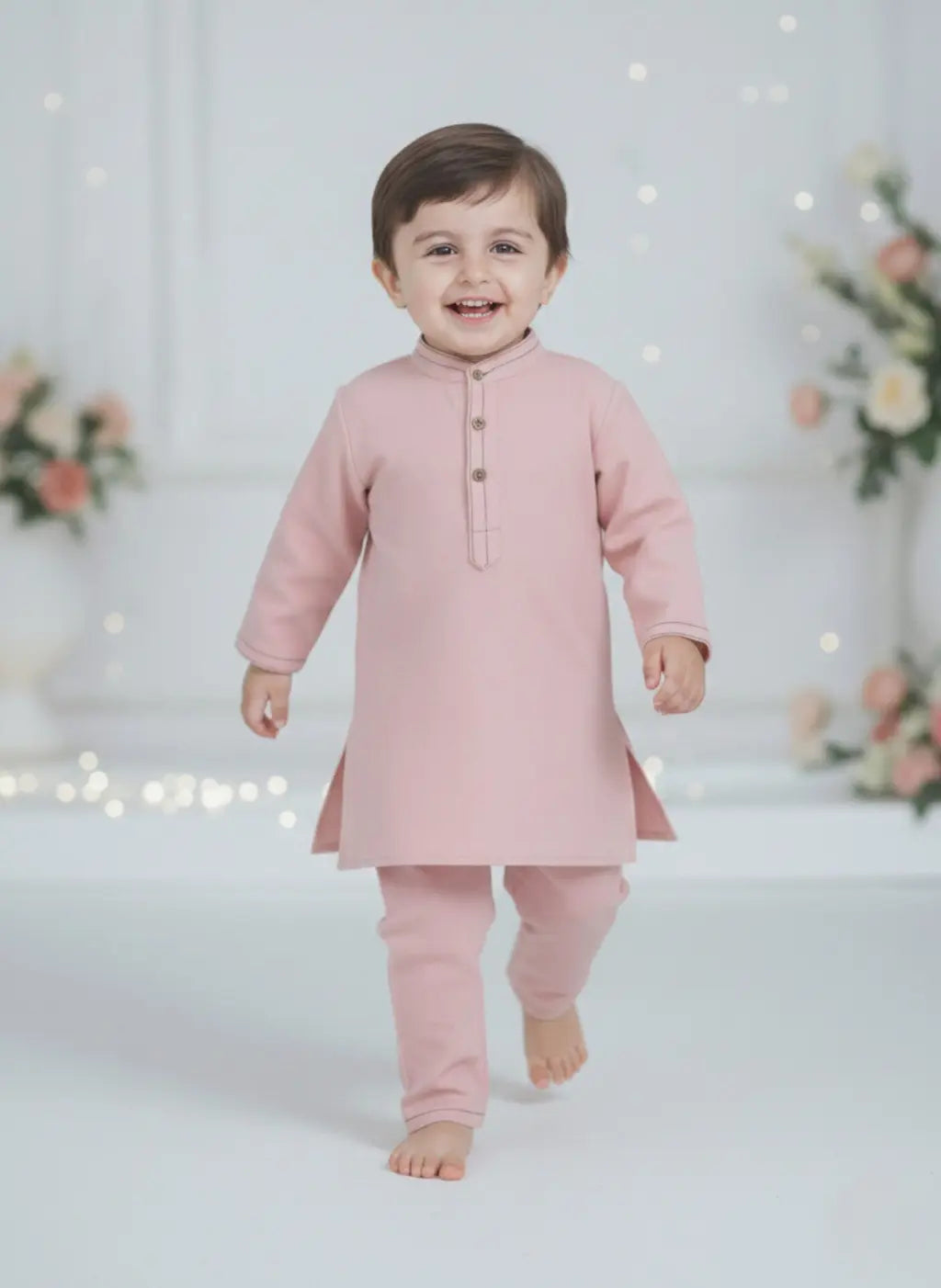 Child wearing a pink traditional outfit with a light background
