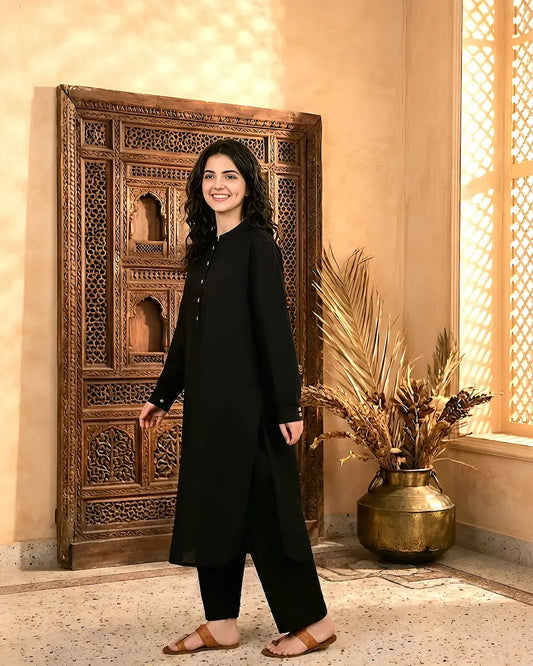 A girl in a black outfit standing in a room with decorative elements