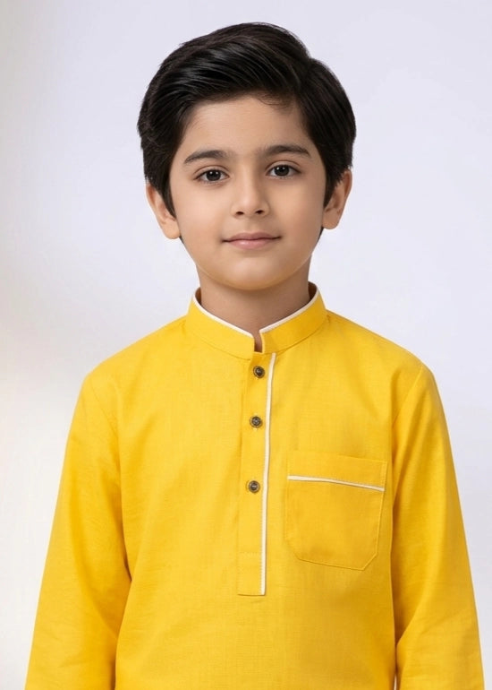 Young boy wearing a yellow kurta with a white background
