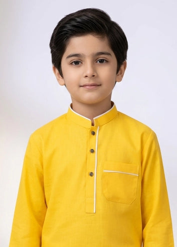 Young boy wearing a yellow kurta with a white background