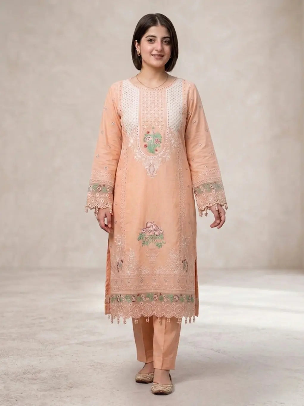 Woman wearing a peach embroidered traditional outfit on a plain background