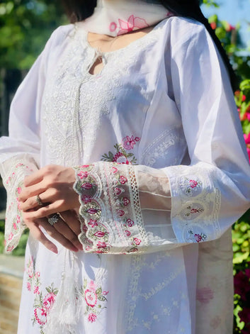 White embroidered outfit with floral patterns in an outdoor setting