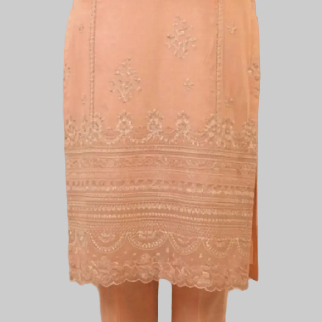 Peach-colored lace dress with intricate patterns on a neutral background