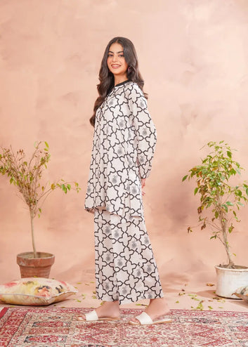 Woman wearing a floral dress standing in a room with plants and a rug.