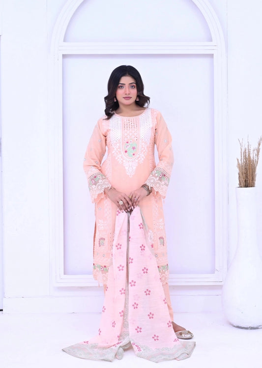 Front view of a woman wearing a peach ethnic ensemble from Sparkles Pret. The outfit features intricate white embroidery on the neckline and sleeves, paired with a light pink dupatta adorned with small red floral patterns.