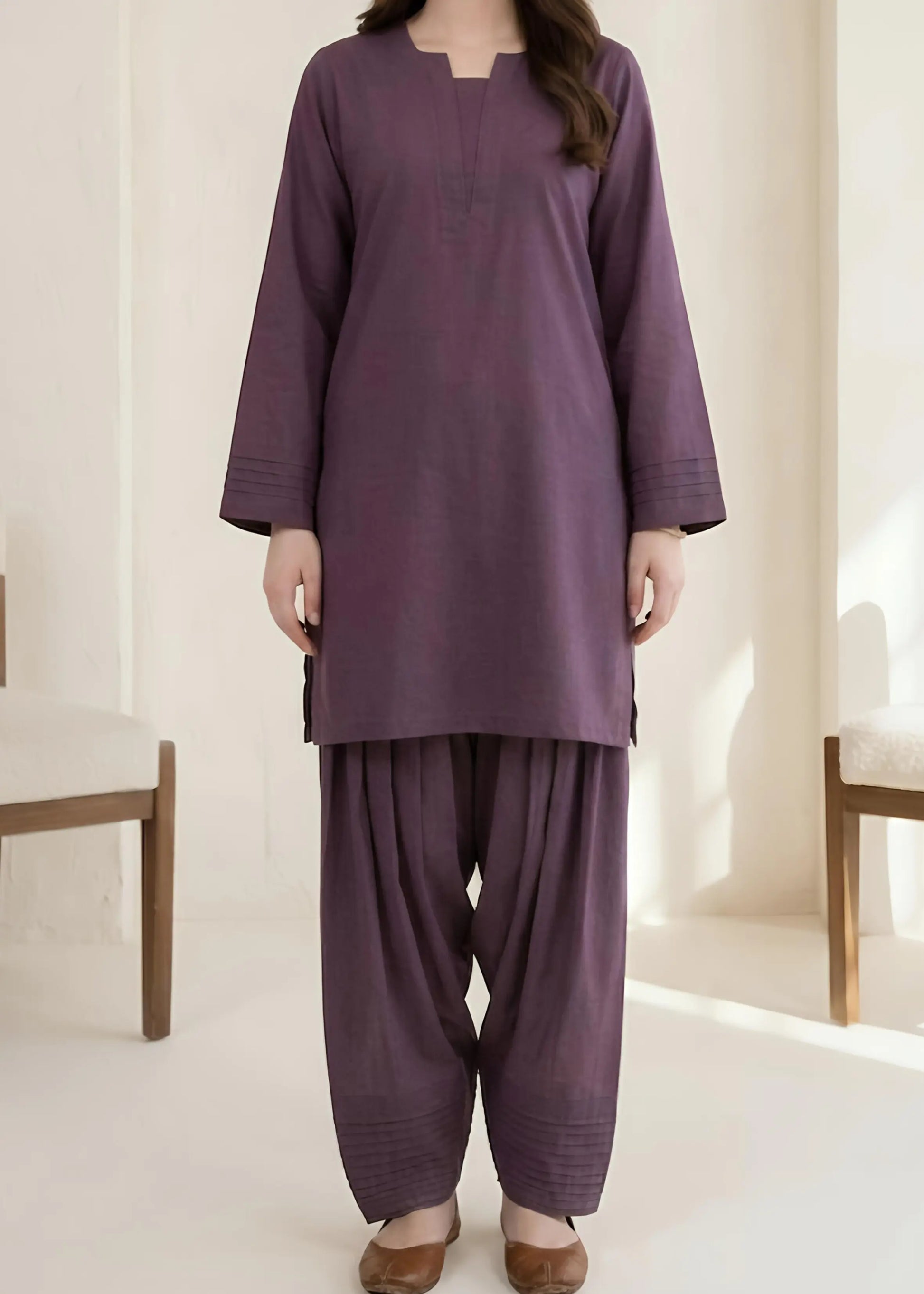 Person wearing a purple traditional outfit with a plain background