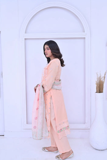 Woman in a peach traditional outfit with a white background