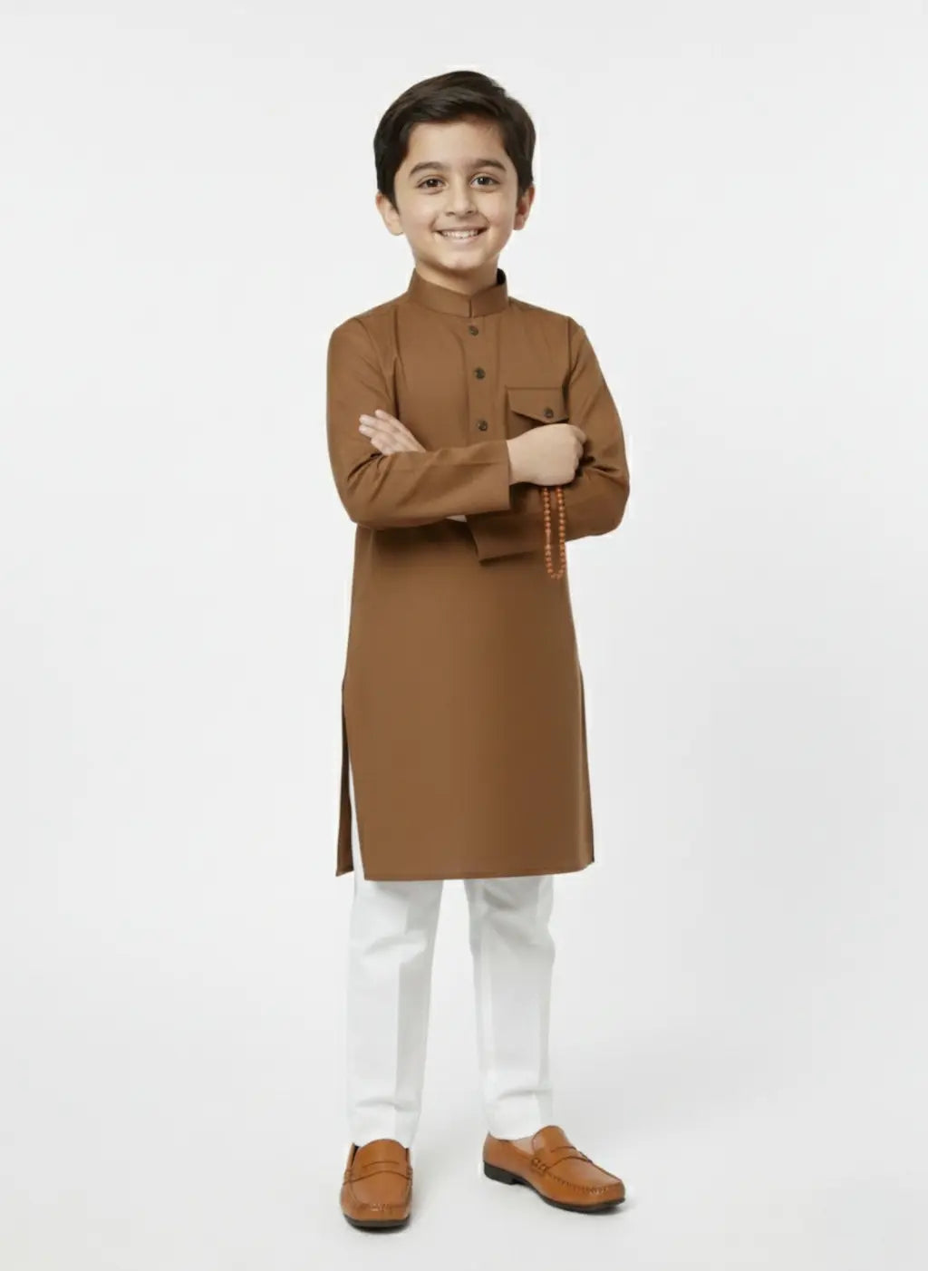Young boy wearing a brown kurta with white pants on a white background