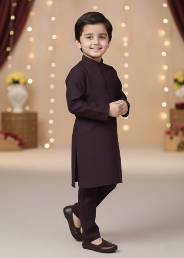 Child wearing a dark brown kurta with pants in a decorated indoor setting.
